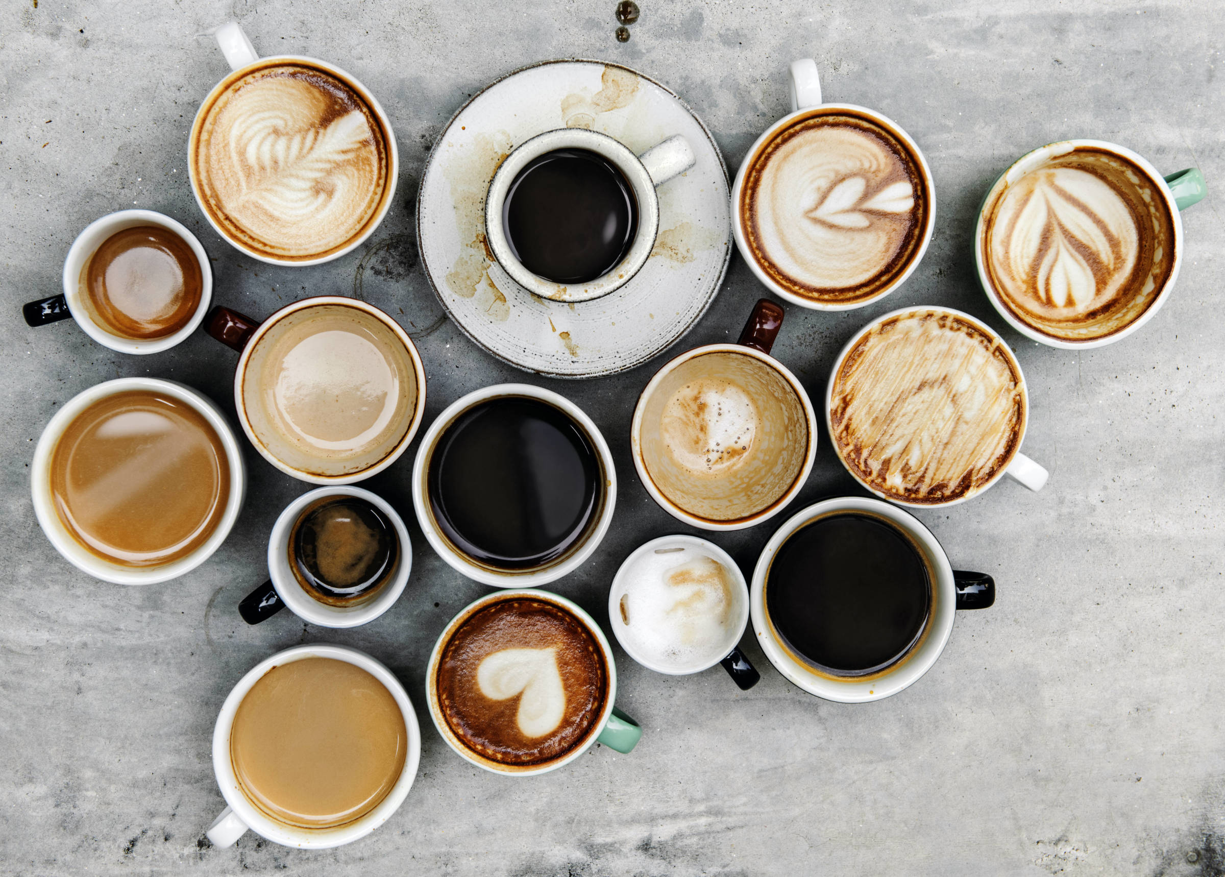 Erilaisia kahvikuppeja ylhäältäpäin kuvattuna: kahvia mustana, maidolla, lattena, espressoja. Kaikilla työpaikoilla juodaan kahvia, mutta meillä jokaisella on omanlainen kahvimakumme, ja kuppien koko ja tyylikin usein vaihtelee. Kuppikokoelma muodostaa ylös- ja eteenpäin osoittavan nuolikuvion, mikä symboloi toiminnan kehittämistä.